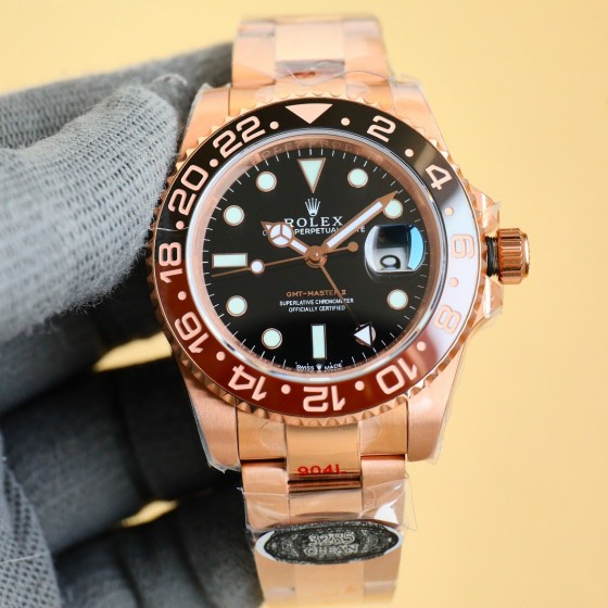 Rolex GMT-Master series, black dial, black and red bezel, 40mm, gold and silver Oyster bracelet.